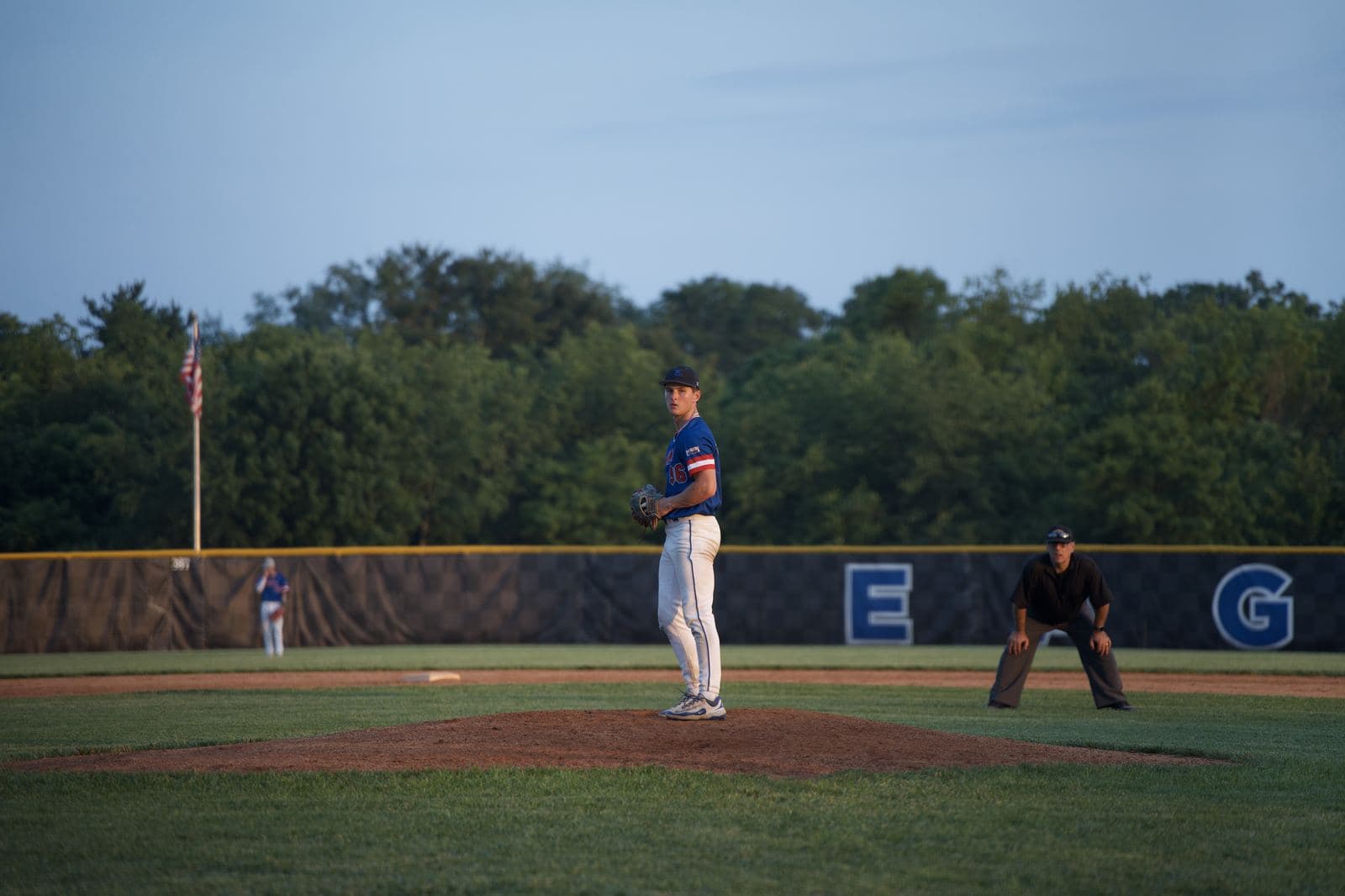 A pitcher set on the mound during a game on his own field